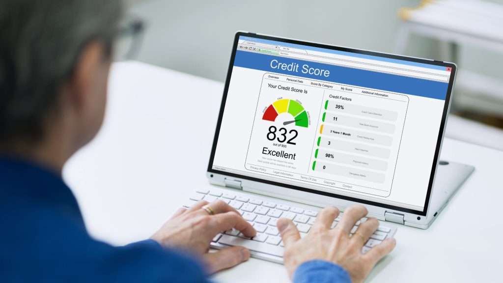 Person checking credit score on laptop, ideal auto bensonhurst pre owned car brooklyn